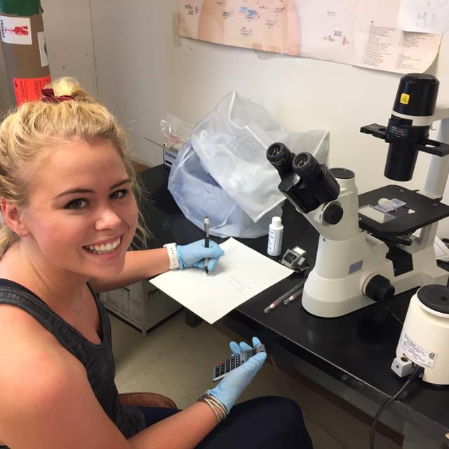 student using microscope