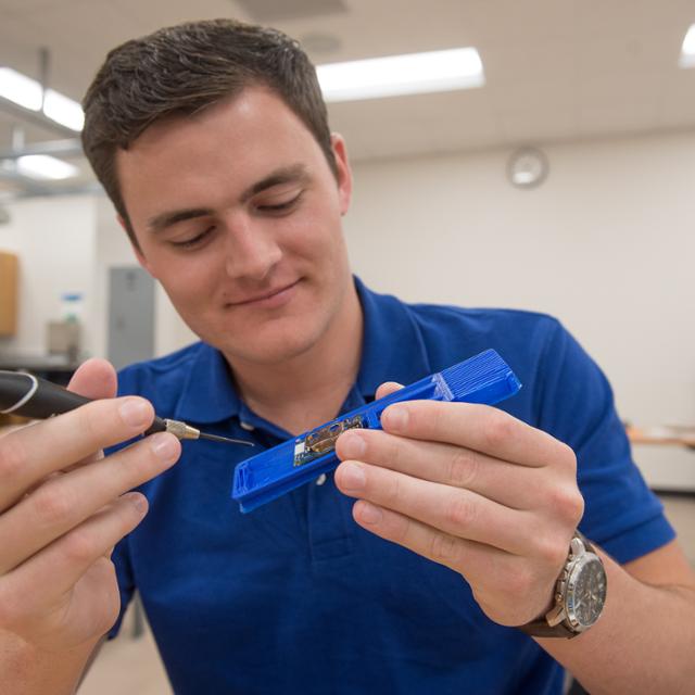 student using a screwdriver in a lab