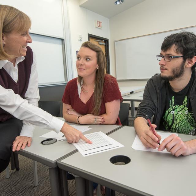 professor teaching two students