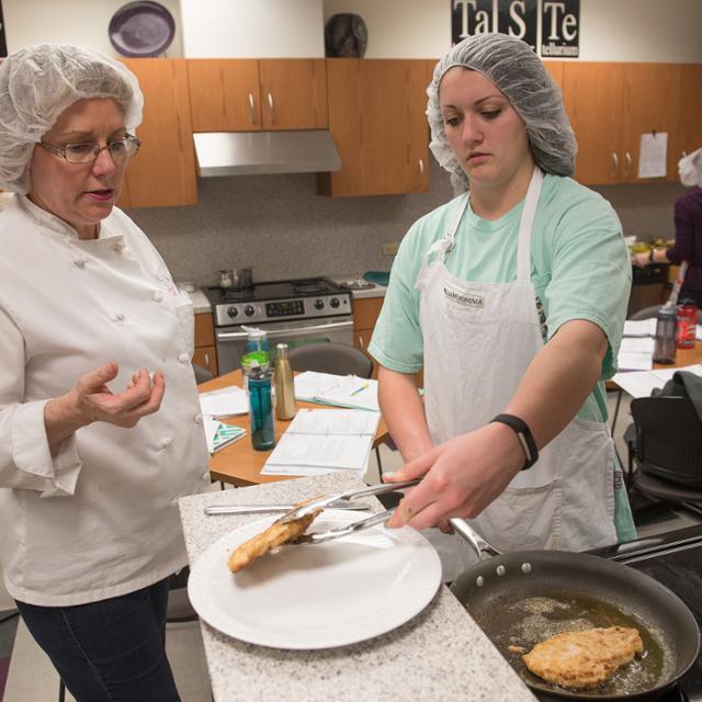 professor and student preparing a plate