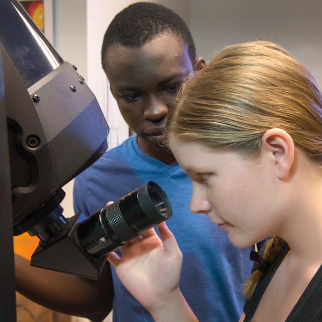 student looking through a micoscope