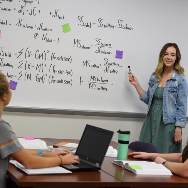 student working on a white board
