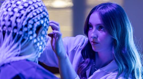 A psychologist interacts with a patient while performing an EEG exam