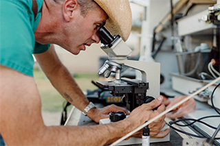 Dr. Jeremy Echols looking at a slide under a microscope